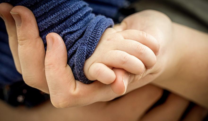 adult holding child's hand